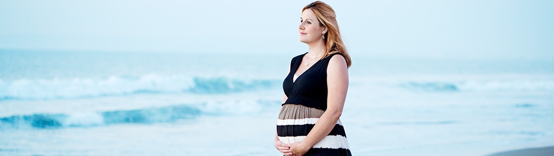 Ostomate Amy walking pregnant on the beach